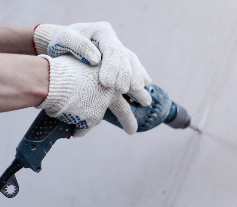 man worker hammer drills wall